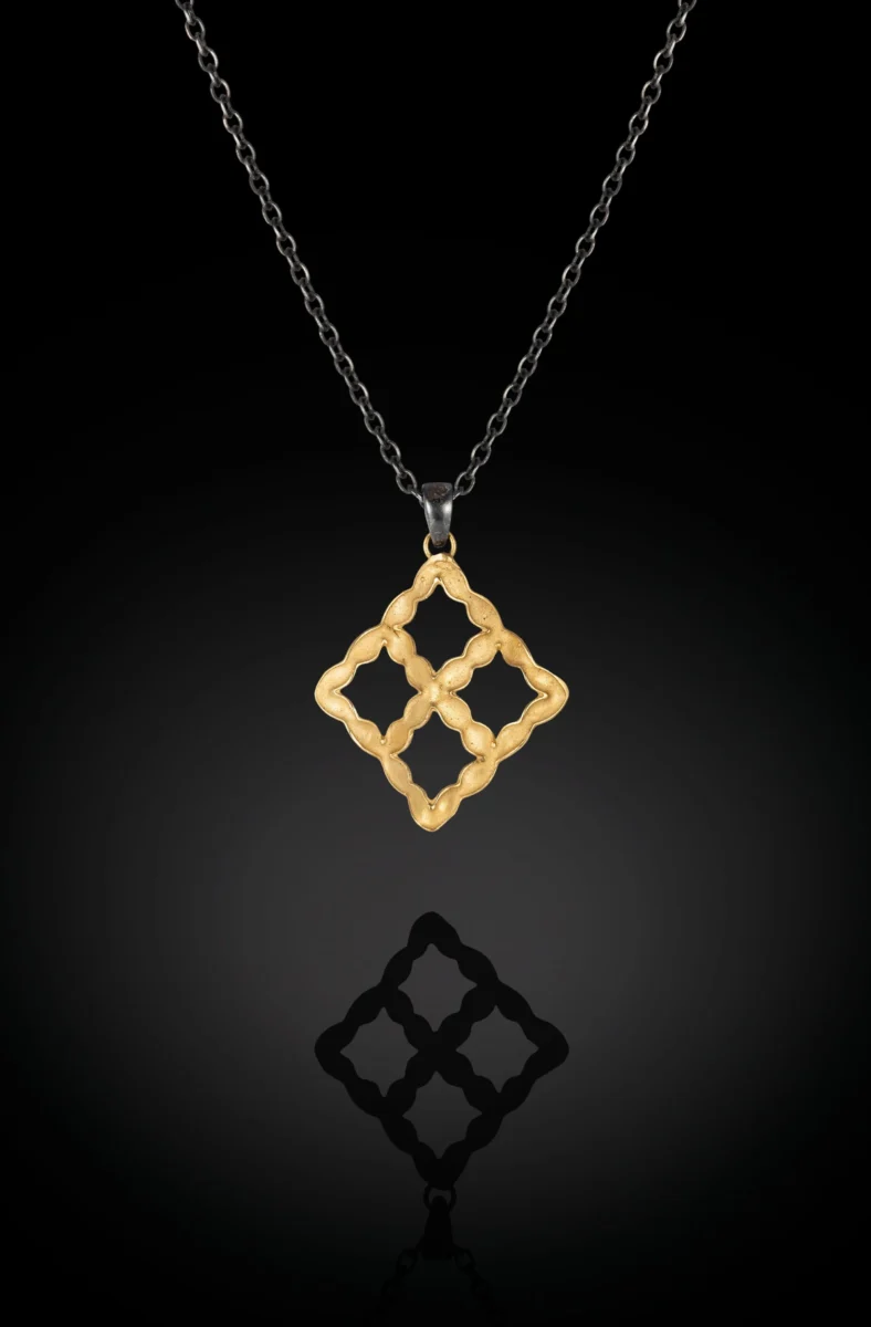ShiraniFernando-LightandShadowssmallnecklacewithblackchainonblackbackbround.webp