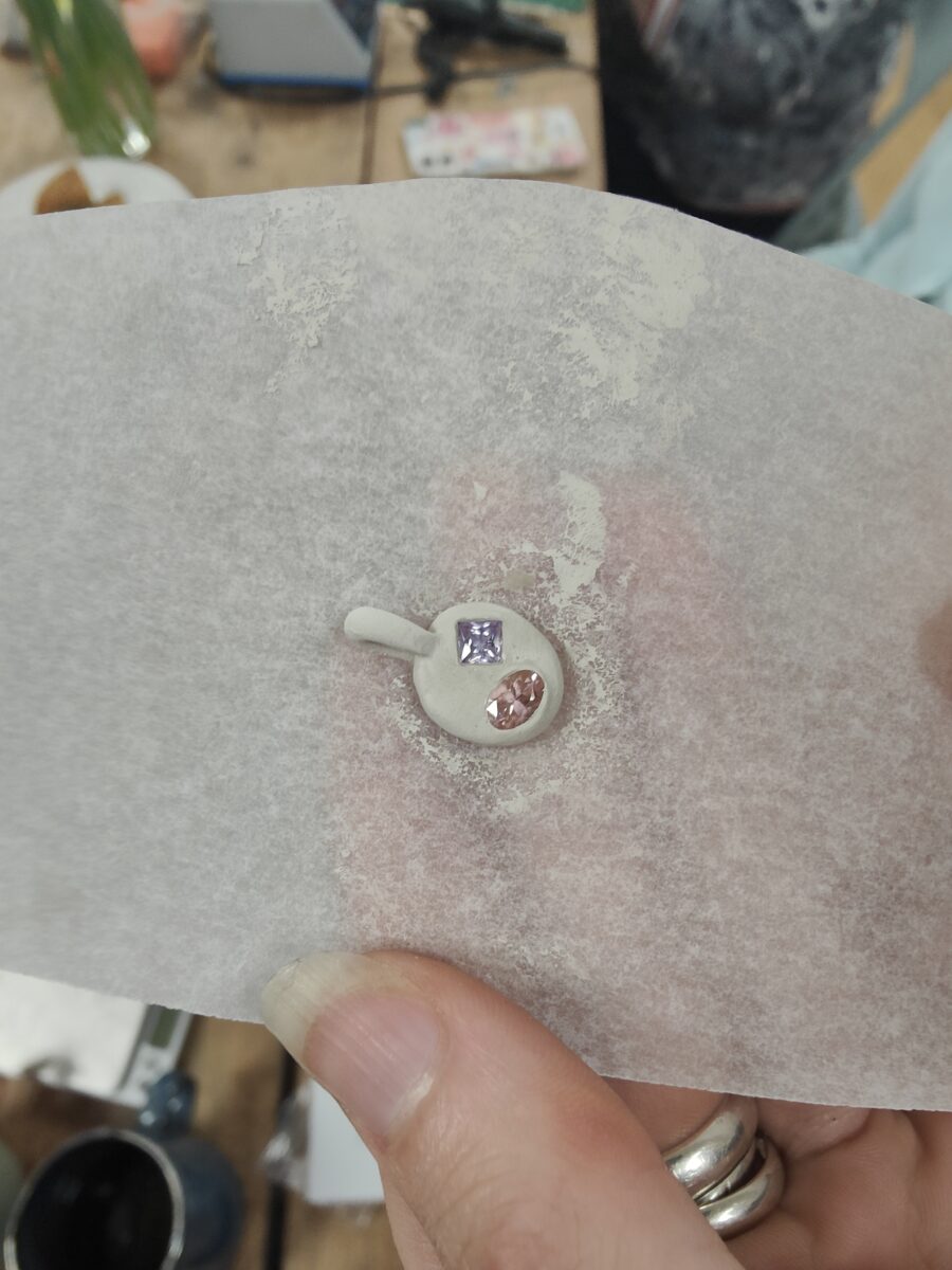 a silver clay charm with gemstones before being fired