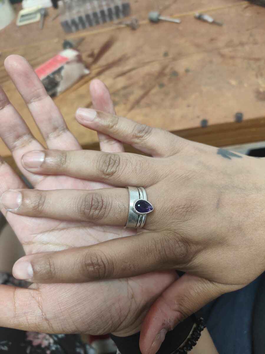 a stacked set of three rings make in workshops. One has a teardrop amethyst set onto the ring.