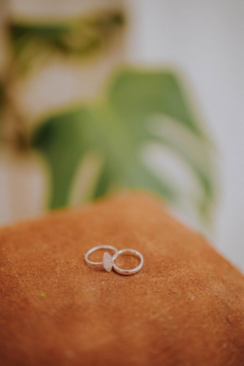 pair of silver rings sit on a brown sandbag