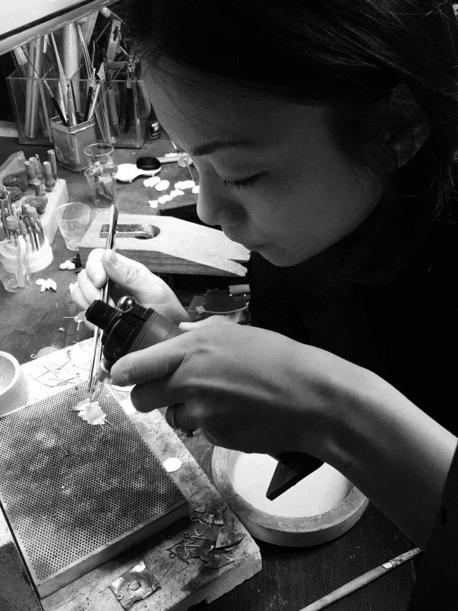 Jeweller soldering something small on a soldering block on a jewellers bench